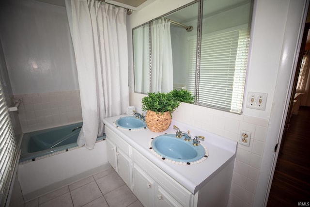 bathroom featuring double vanity, tile patterned flooring, shower / bathtub combination with curtain, and tile walls