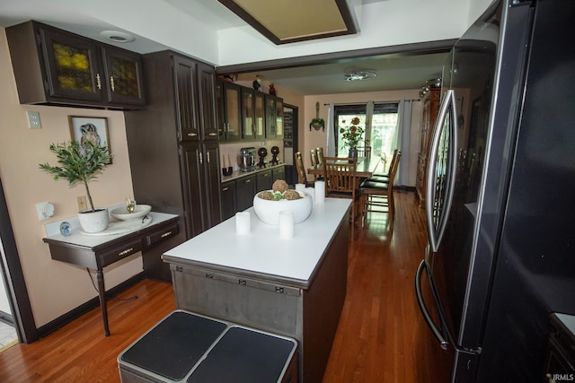 kitchen featuring dark hardwood / wood-style floors, a center island, and black refrigerator