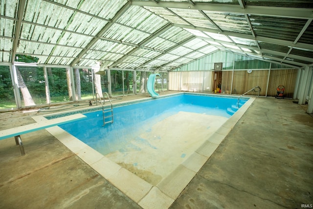 view of swimming pool with a water slide and a diving board