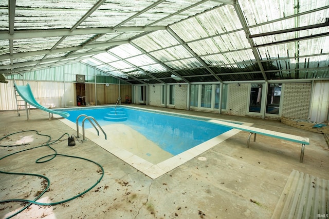 view of pool with a water slide and a diving board