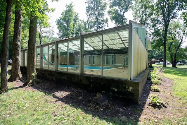 rear view of property featuring a yard and a lanai