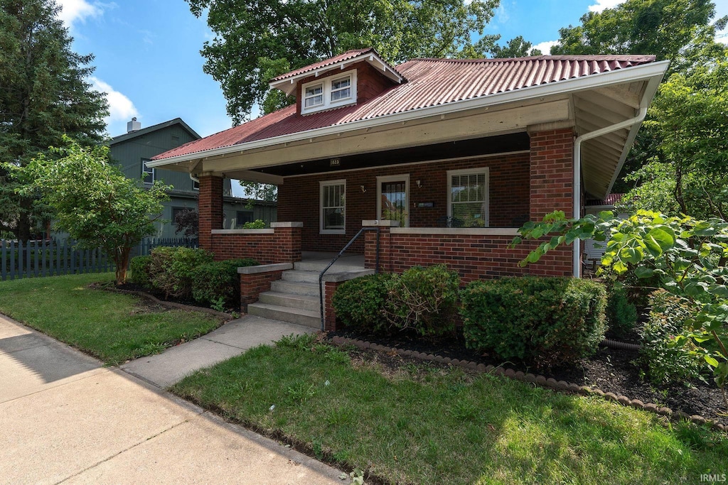 view of front facade featuring covered porch and a front yard