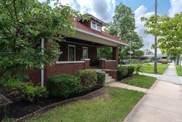 view of front of house with covered porch and a front yard