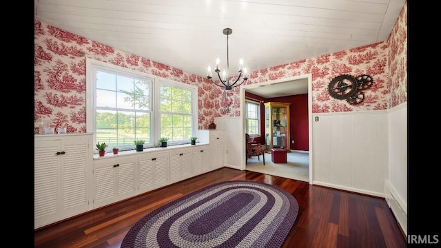 dining room with dark hardwood / wood-style floors and an inviting chandelier