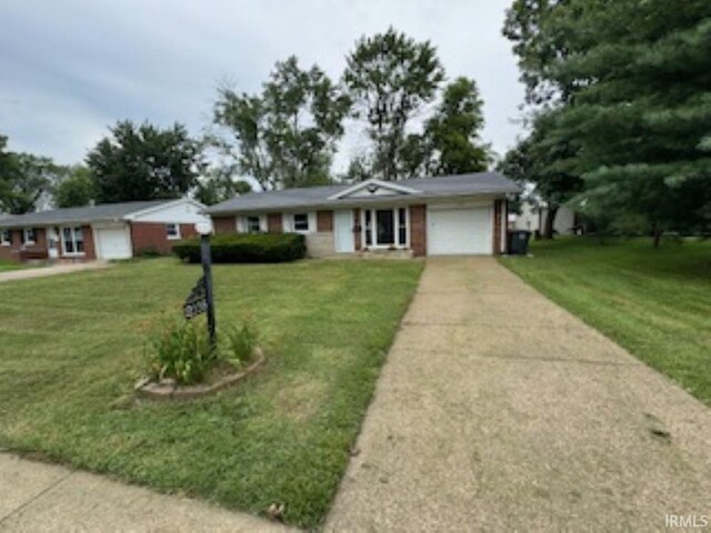 single story home featuring a garage and a front yard