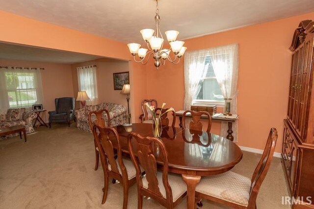 dining space with a notable chandelier and carpet floors