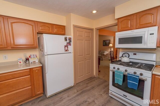 kitchen with hardwood / wood-style flooring and white appliances