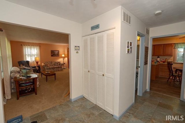 corridor featuring light colored carpet