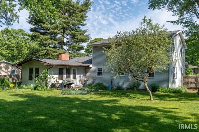 rear view of property featuring a yard