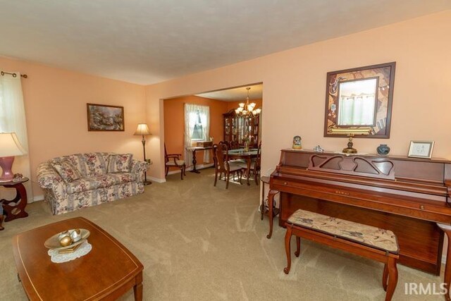 carpeted living room with a notable chandelier