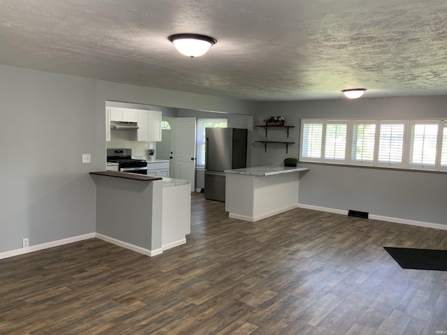 kitchen with kitchen peninsula, a textured ceiling, dark hardwood / wood-style flooring, white cabinetry, and appliances with stainless steel finishes