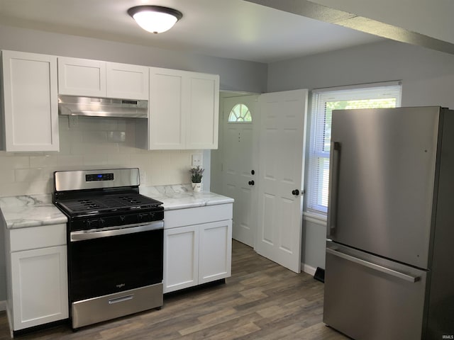 kitchen featuring white cabinets, stainless steel appliances, and tasteful backsplash