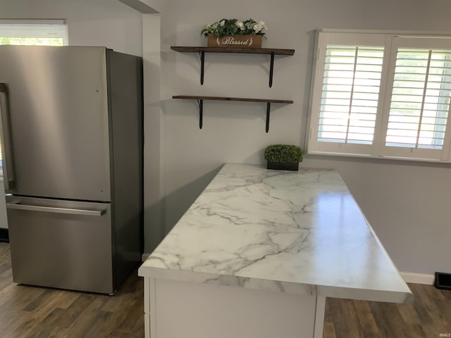 kitchen featuring stainless steel fridge and dark hardwood / wood-style flooring