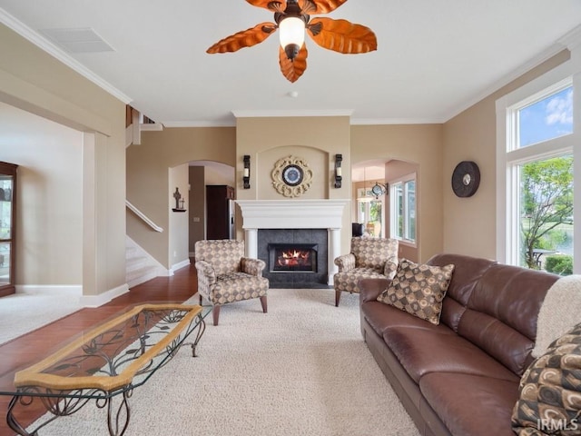 living room featuring a fireplace, ceiling fan, wood-type flooring, and ornamental molding