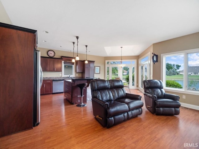 living room featuring sink, hardwood / wood-style flooring, and a wealth of natural light