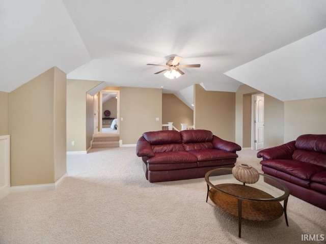 carpeted living room with ceiling fan and vaulted ceiling