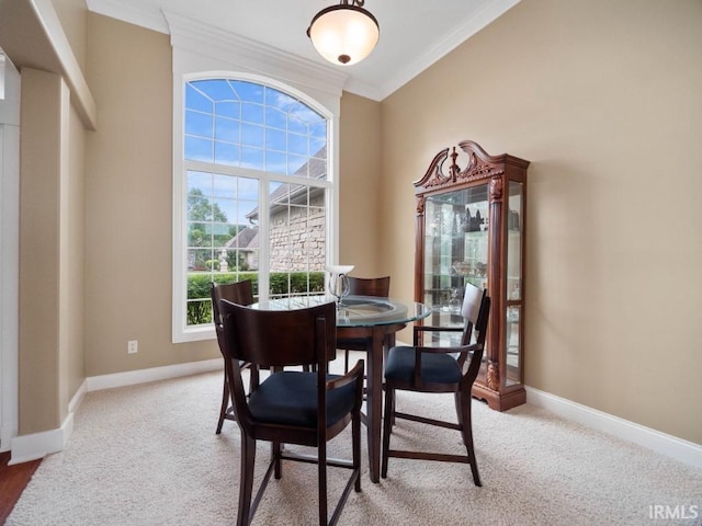 dining space featuring carpet flooring and ornamental molding