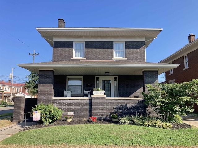 view of front facade with covered porch and a front lawn