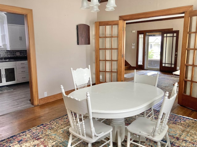 dining room featuring sink, a chandelier, and dark hardwood / wood-style flooring