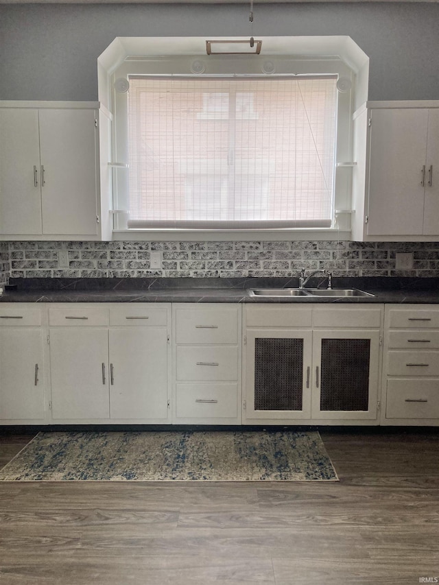 kitchen with white cabinetry, dark hardwood / wood-style floors, sink, and decorative backsplash