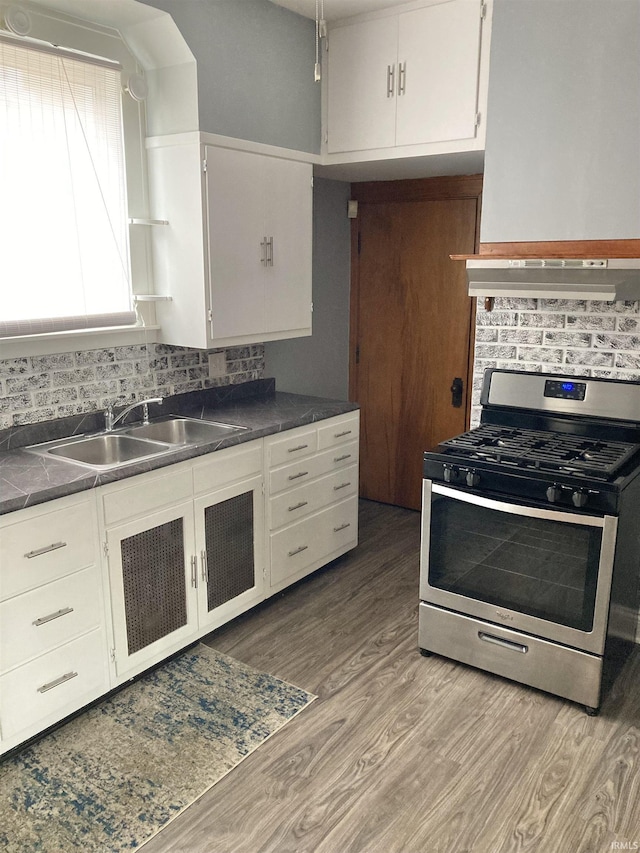 kitchen with sink, white cabinetry, tasteful backsplash, light hardwood / wood-style flooring, and stainless steel range with gas stovetop