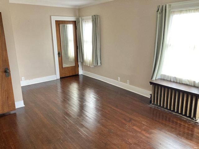 unfurnished room featuring dark wood-type flooring, radiator heating unit, and ornamental molding