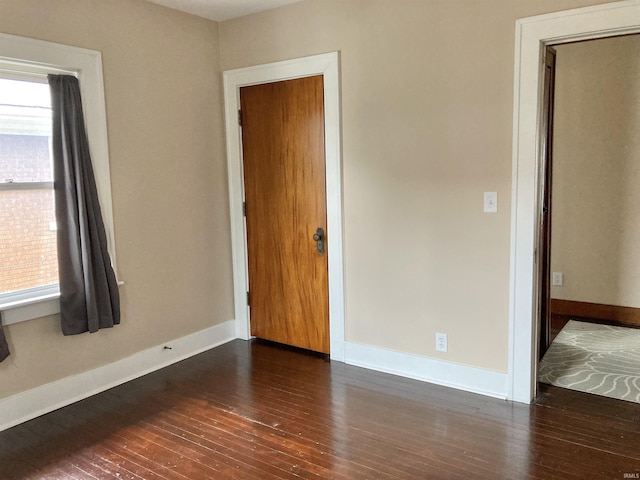 unfurnished room featuring a healthy amount of sunlight and dark hardwood / wood-style floors