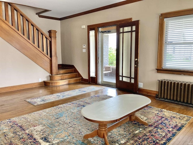 entrance foyer featuring ornamental molding, radiator heating unit, and hardwood / wood-style floors