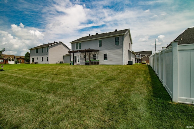 back of property with a yard, a pergola, and central AC