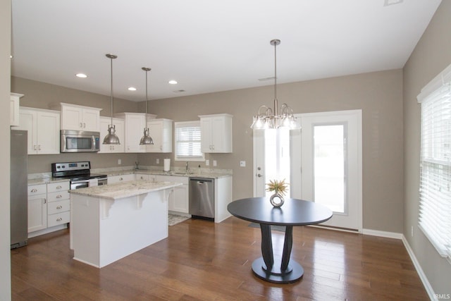 kitchen featuring white cabinetry, appliances with stainless steel finishes, a center island, and pendant lighting