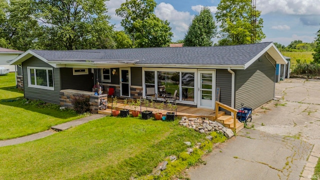 rear view of house with covered porch and a lawn