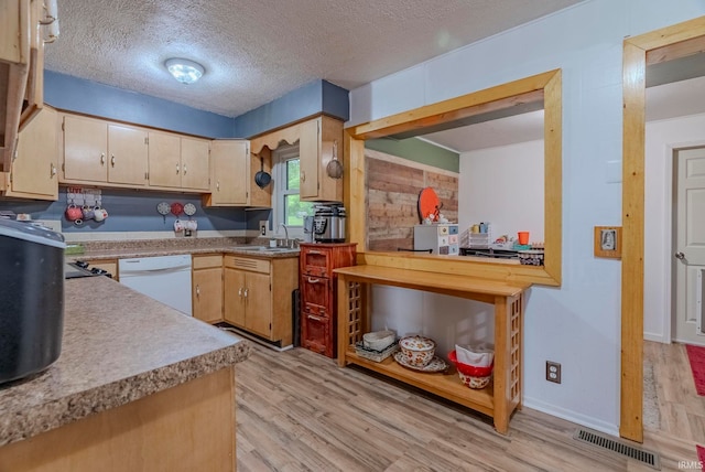 kitchen with sink, dishwasher, light hardwood / wood-style floors, and a textured ceiling