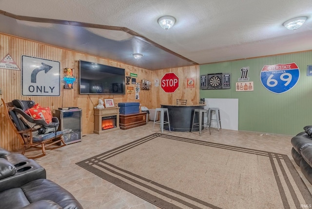 living room featuring a textured ceiling and wood walls