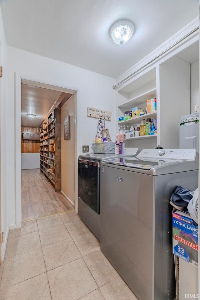 laundry room featuring light tile patterned floors, washer and clothes dryer, and built in features