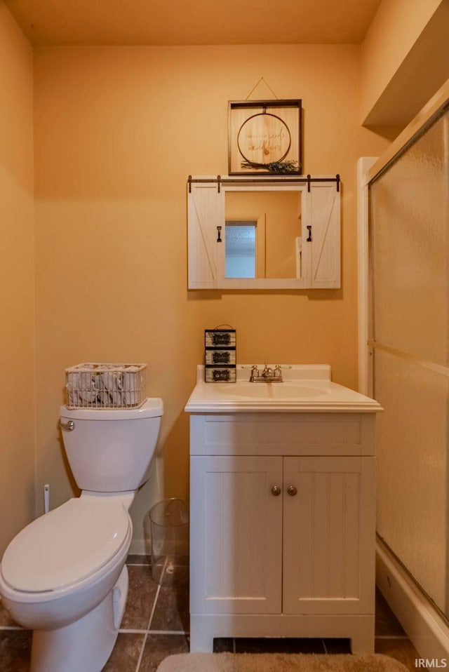 bathroom featuring vanity, tile patterned floors, toilet, and walk in shower