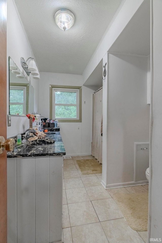 bathroom with vanity, tile patterned floors, toilet, and a textured ceiling