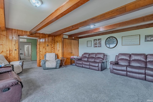 living room with beamed ceiling, wooden walls, and carpet