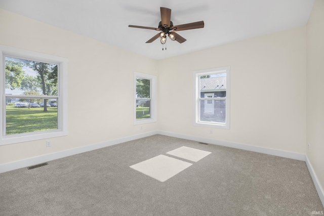 carpeted spare room featuring ceiling fan