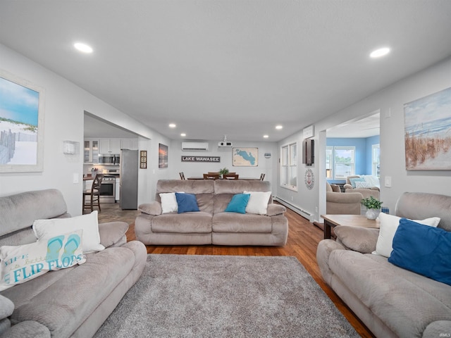 living room featuring wood-type flooring, a baseboard heating unit, and a wall mounted air conditioner