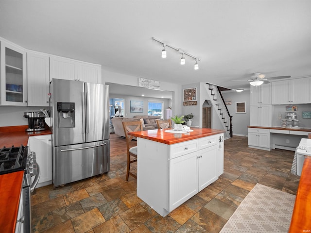 kitchen with ceiling fan, stainless steel appliances, and white cabinets