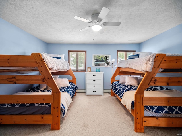 carpeted bedroom with ceiling fan, a textured ceiling, and multiple windows