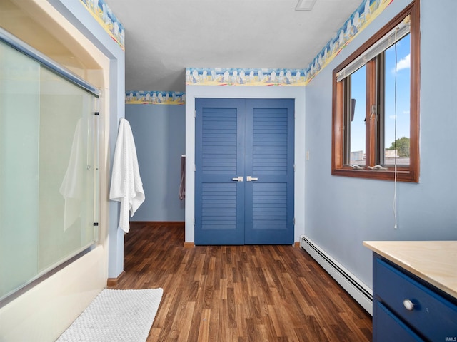 bathroom featuring hardwood / wood-style flooring, a baseboard heating unit, and vanity