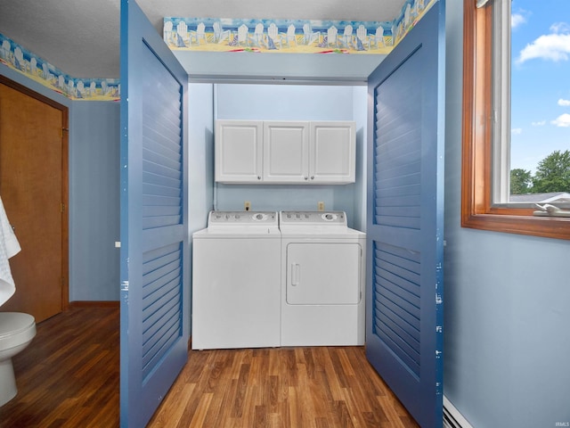 laundry room featuring cabinets, dark hardwood / wood-style flooring, and independent washer and dryer