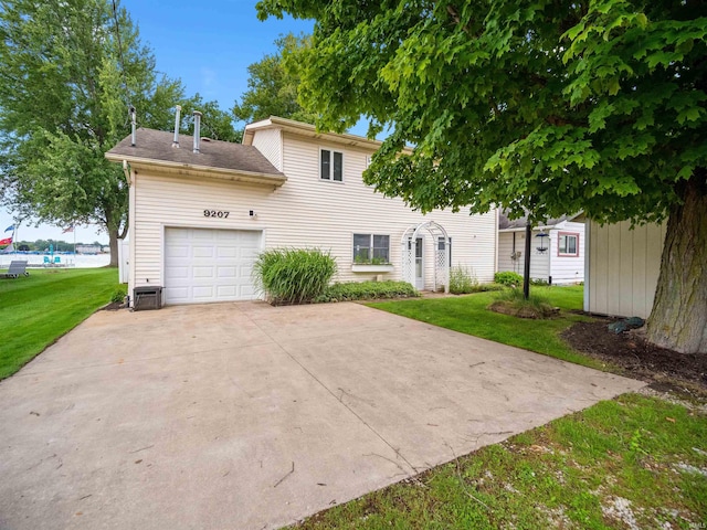 back of property featuring a lawn and a garage