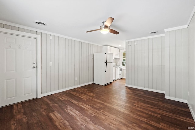 unfurnished living room featuring ornamental molding, dark wood-type flooring, visible vents, and a ceiling fan