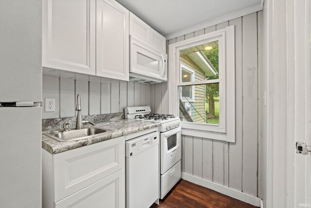 kitchen featuring dark hardwood / wood-style flooring, white cabinets, white appliances, sink, and light stone counters