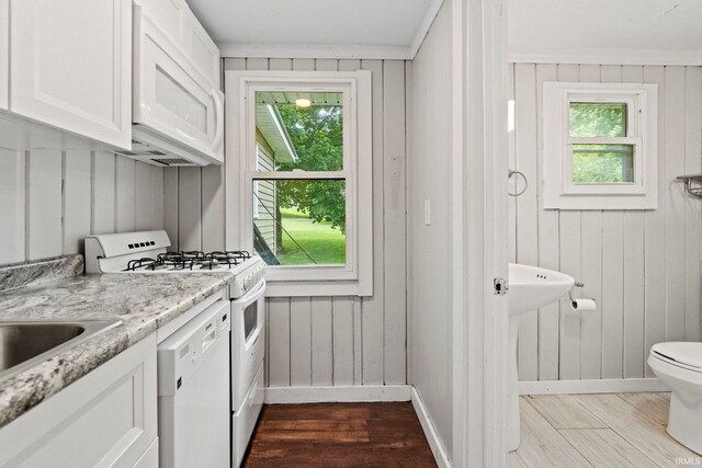 kitchen featuring white cabinetry, hardwood / wood-style flooring, plenty of natural light, and white appliances