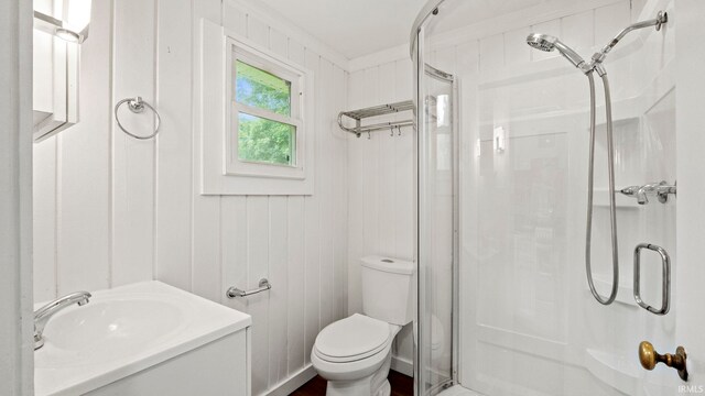 bathroom with a shower with door, crown molding, toilet, and vanity