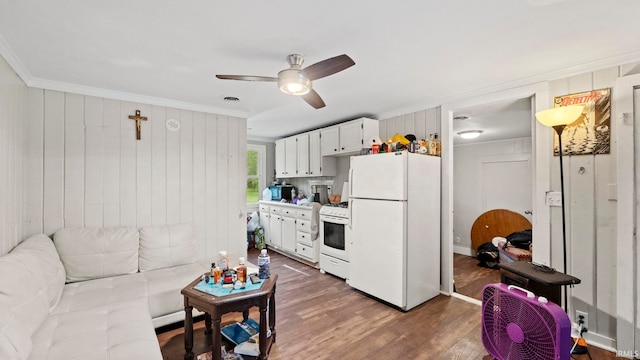 living area featuring dark wood-type flooring, visible vents, ornamental molding, and ceiling fan