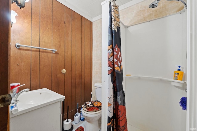 bathroom with wood walls, crown molding, toilet, and vanity